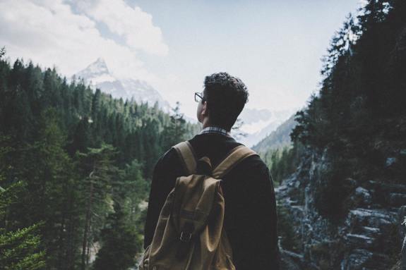 Man backpacking through forest. 
