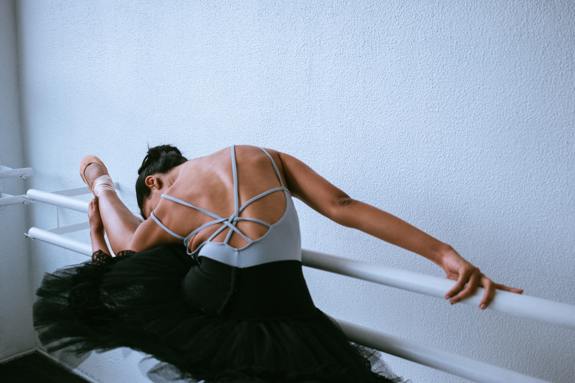 Ballerina stretching on a bar. 